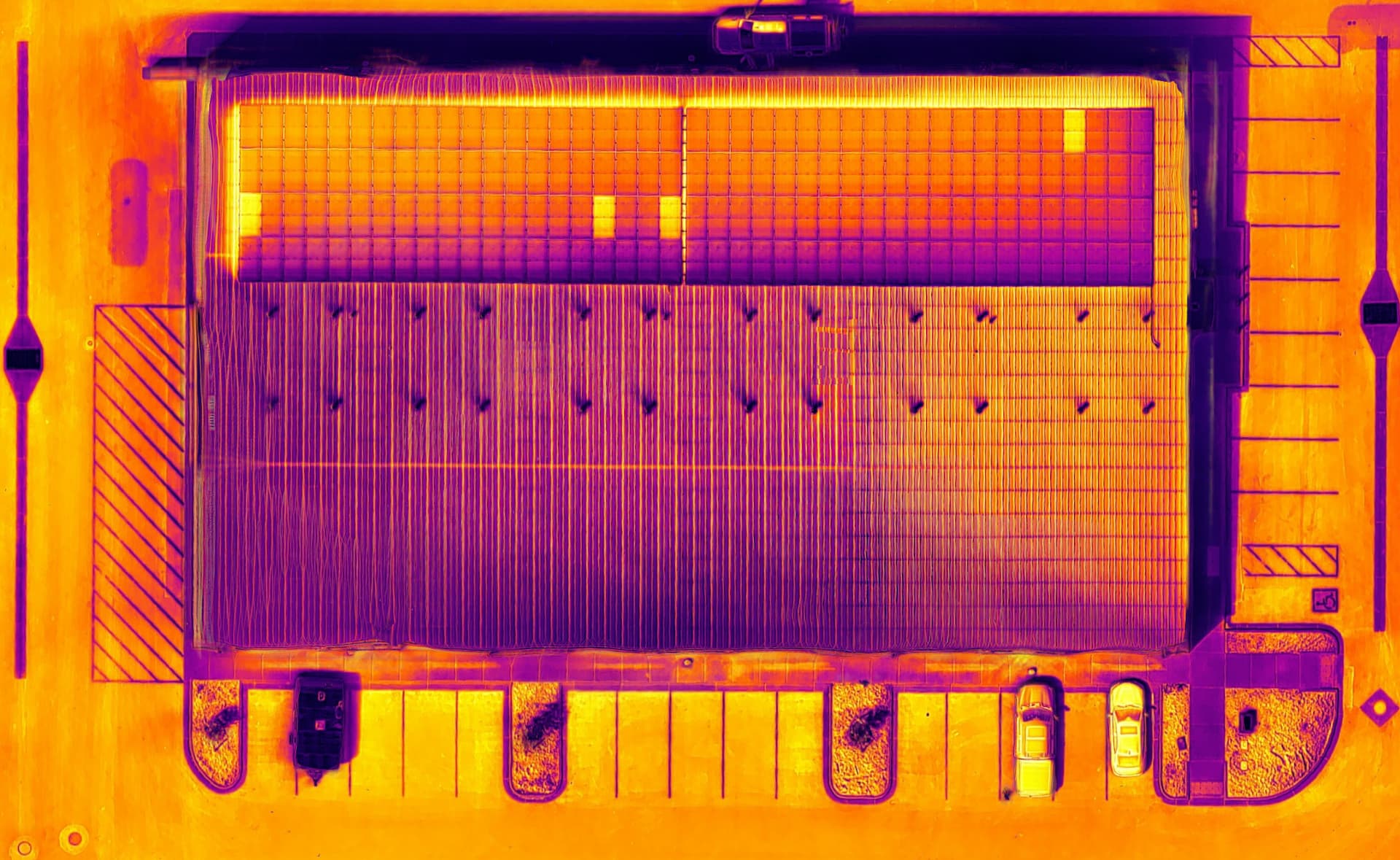 Thermal orthomosaic of a commercial facility roof and solar array with temperature anomalies
